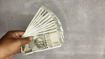 Hand hold Indian new currency 500 rupees bank note isolated on white wall background with copy...
