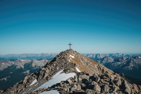 A picturesque mountain summit featuring a wooden cross in front, set against a bright blue sky with rugged landscape and faraway snowy mountains - Powered by Adobe