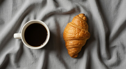 Indulgent morning coffee and golden croissant create perfect cozy breakfast scene