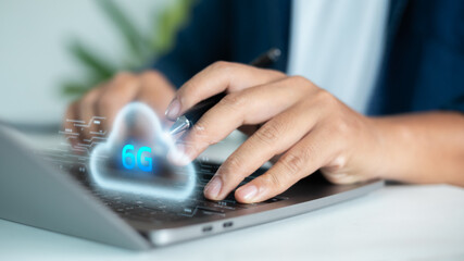 Hand typing on a laptop with digital hologram cloud 6G. Concept of cloud computing, wireless technology, high-speed internet, future communication, IoT, data transfer, and digital innovation.