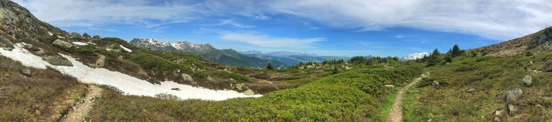 Naklejka premium Wide panorama of alpine landscape with snowy mountains and clear sky
