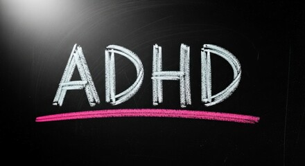 ADHD written in chalk on a dark chalkboard