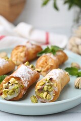 Delicious cannoli with cheese, nuts and mint on table, closeup
