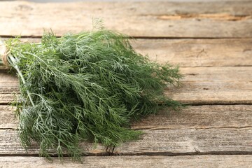 Bunch of fresh dill on wooden table, closeup. Space for text