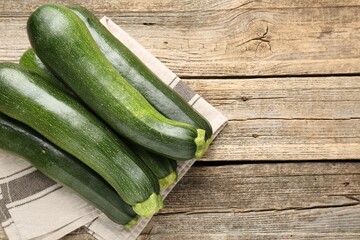 Fresh ripe zucchinis on wooden table, top view. Space for text