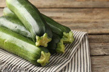 Fresh ripe zucchinis on wooden table, closeup. Space for text