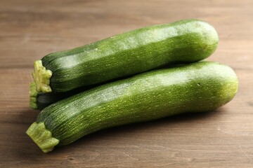 Fresh ripe zucchinis on wooden table, closeup