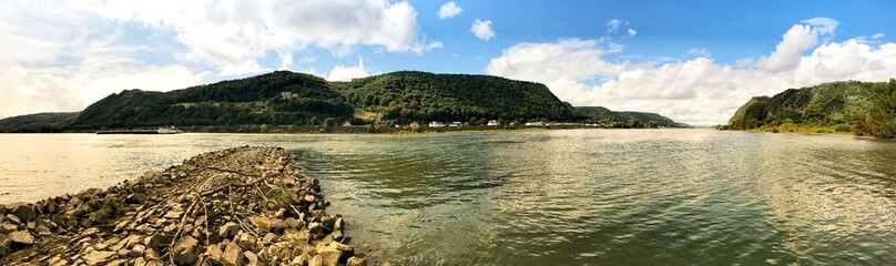 Wide panoramic view of scenic river with hills and lush landscape