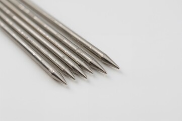 Set of sewing needles on a plain white surface