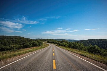 Naklejka premium Asphalt highway stretching into the distance through a summer countryside