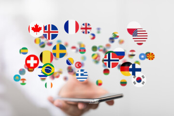 Image of various country flags floating above a smartphone, representing global communication and...