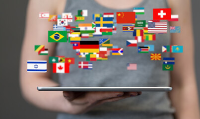 Image depicts global reach and connection.  Flags from various countries appear above a tablet.
