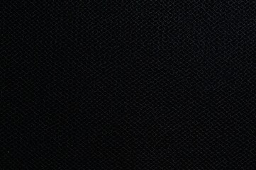 Close-up of black perforated mesh with speaker grille pattern