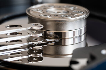 Close up of parts inside hard disk drive, actuator arm with read/write head and spindle holding...