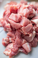 Raw meat with fat, cut into pieces close-up. Pink pork fat. Cut pork pieces for cooking. Fresh ingredients for marinating and barbecue. Fresh meat products