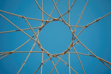 A network of intertwined ropes creating a circular framework symbolizing teamwork and unity in a professional setting.