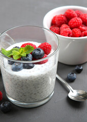 chia pudding with natural yogurt and fresh berries close-up on the table.. Vertical photo format