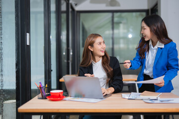 Fototapeta premium Accountants or business people working together on a project. Two female business colleagues are working on computers.