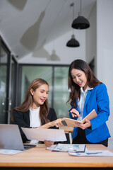 Accountants or business people working together on a project. Two female business colleagues are working on computers.
