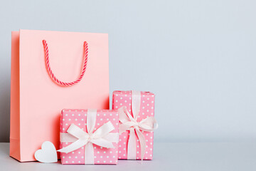 Shopping bag with gift box on colored background perspecrive view. Space for text holiday concept