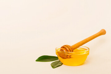 Honey in jar with leaves and honey dipper on colored background top view with copy text