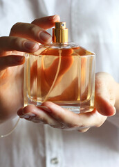The girl uses perfume. Perfume in female hands.. Vertical photo format