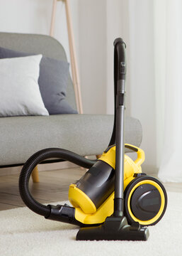 Vacuum cleaner yellow in the interior of the room. Vertical photo format