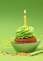 Delicious cupcake with a candle on a colored background with space for text.. Vertical photo format