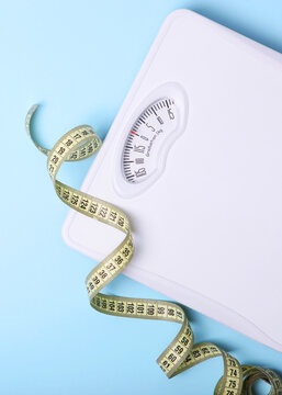 floor scales and tape measure on a colored background top view. Vertical photo format