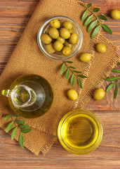 olive oil, green leaves and olives on the table.. Vertical photo format