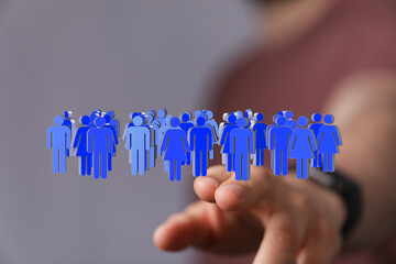 Image depicting a hand interacting with a digital representation of a diverse group of people,...