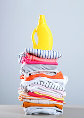 Laundry detergent bottles and clothes on the table. Household chemicals. Vertical photo format