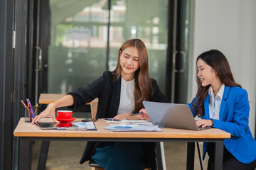  Accountants or business people working together on a project. Two female business colleagues are working on computers.