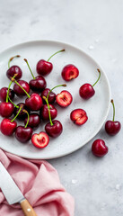 Close-up still life of fresh cherries on a speckled plate with soft lighting.
