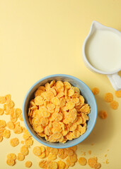 Golden and crunchy cornflakes on a colored background close-up. Vertical photo format