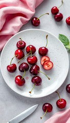 Close-up still life of fresh cherries on a speckled plate with soft lighting.
