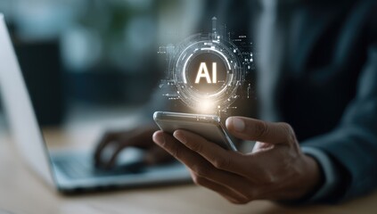 Close-up of hands holding a phone with AI graphic overlay, laptop in the background