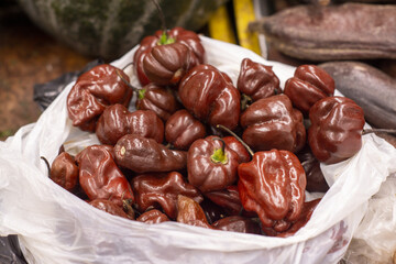 Brown chili peppers in a market bag, close-up