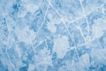 Fototapeta premium Top-down view of a scratched icy surface with skate marks on a blue ice rink floor