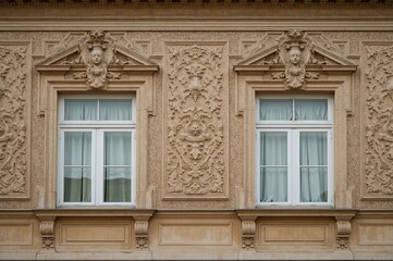 Obraz premium Facade featuring two windows adorned with plaster embellishments, showcasing vintage design and textured patterns on a building exterior
