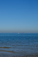 Minimalist Seascape with Vessel and Buoy under Clear Sky