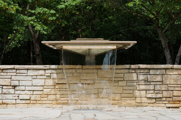 A Fountain on a Stone Wall in a Garden