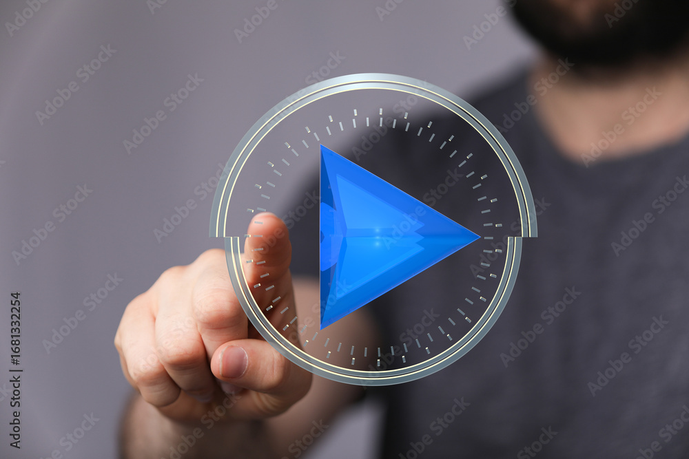 Poster close-up of a hand interacting with a futuristic play button interface.