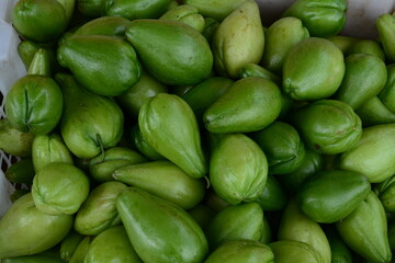 Green tropical fruits piled in a basket with natural lighting