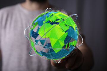 Abstract green polygonal globe in hand. Digital world, global network, connectivity concept.