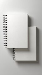 Two Blank White Spiral Notebooks Stacked on Light Gray Background, Top View