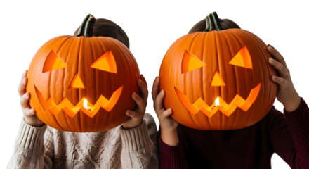 Two children holding carved Halloween pumpkins with glowing lights, celebrating autumn traditions