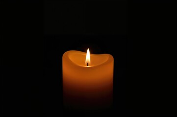 Stock photo of an orange candle glowing