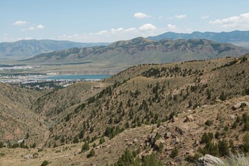 Obraz premium Scenic panorama from a mountain range overlooking a mining operation near a large salt lake during springtime.