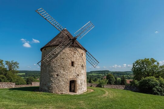 Ancient stone windmill structure in a rural setting - Powered by Adobe